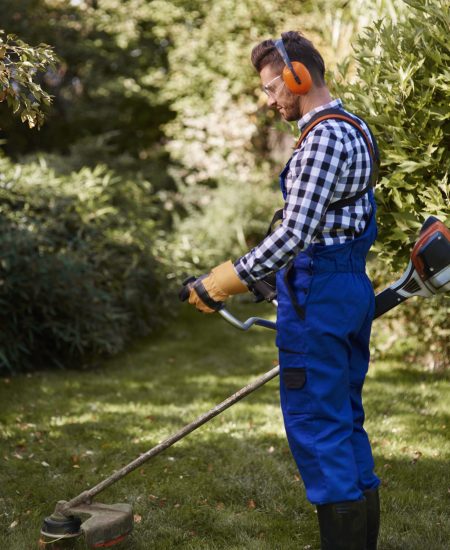 busy-man-using-weedwacker-garden